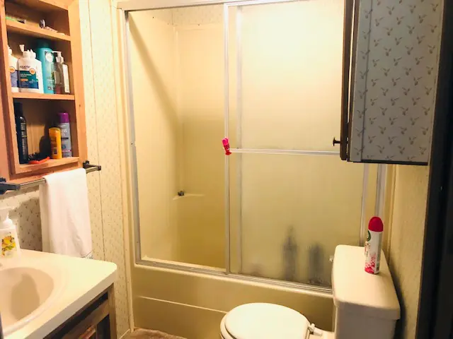 a bathroom with a toilet, shower, and sink