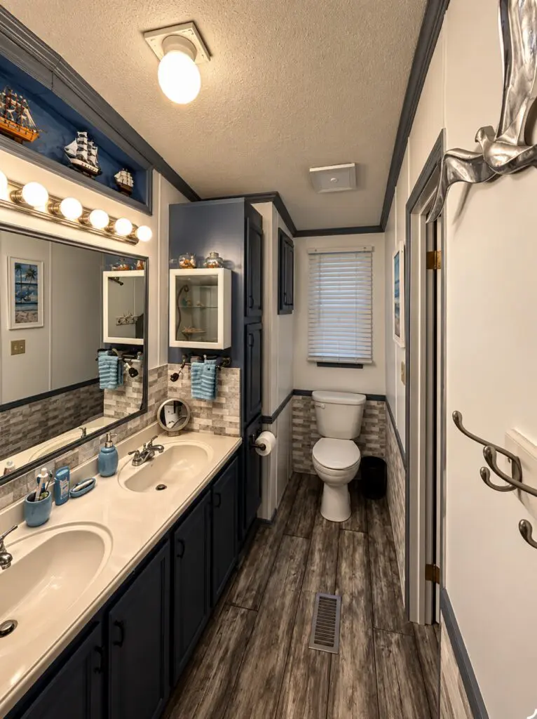 A bathroom with a double sink vanity, toilet, and shower area