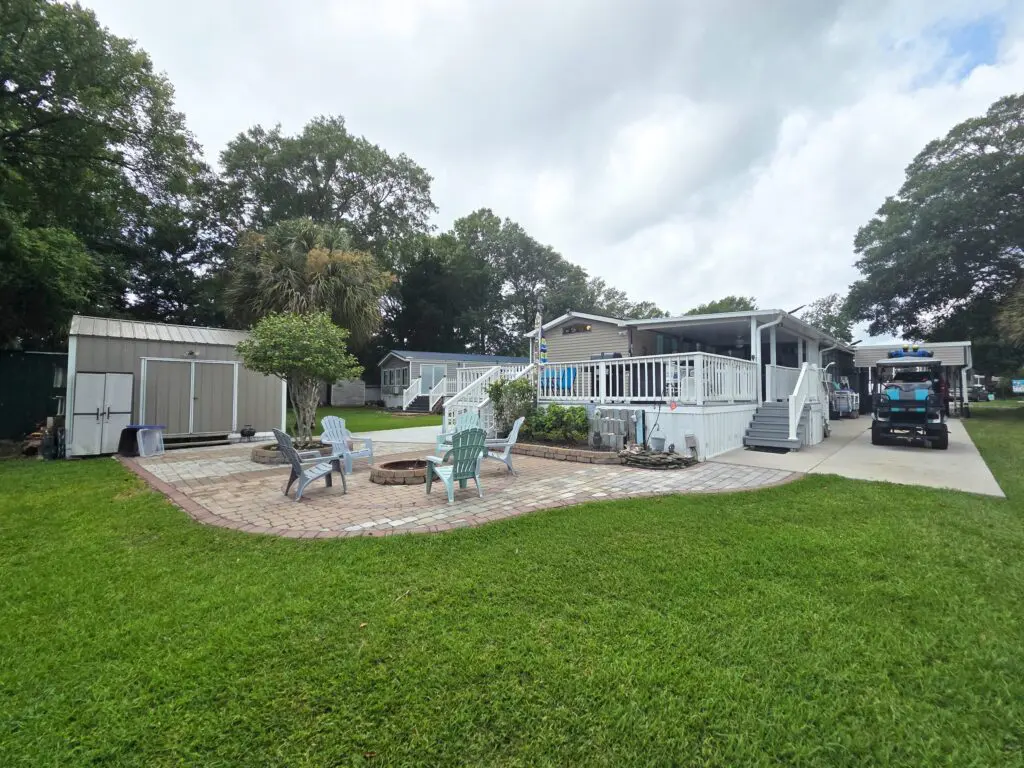 A house with a deck and patio area with outdoor seating and a fire pit.