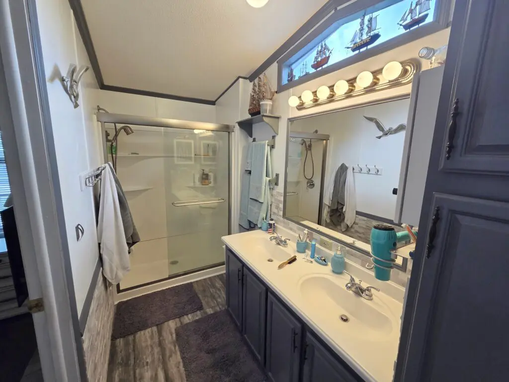 A bathroom with a shower, sink, and mirror