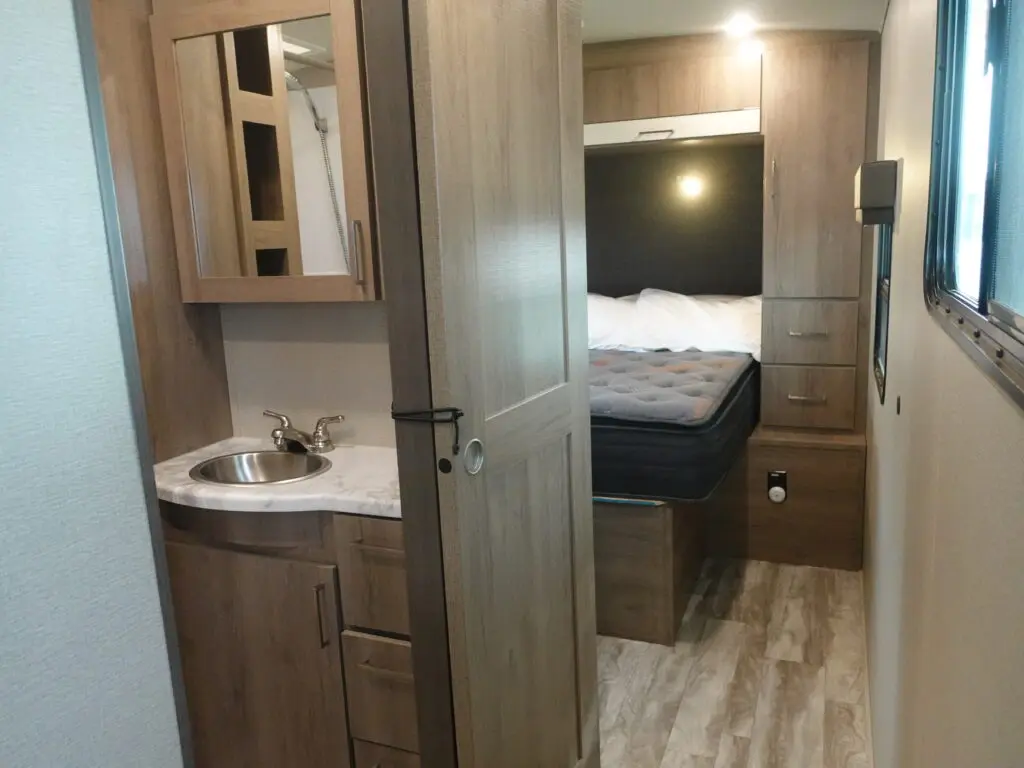 A small room with a bed, sink, and cabinet