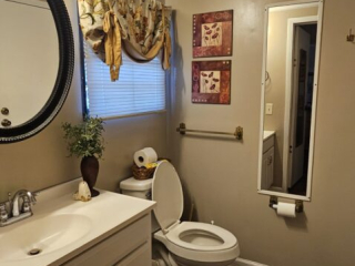 A standard hotel bathroom with a toilet, sink, and mirror