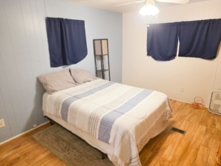 A standard hotel room with a bed, window, and lamp.