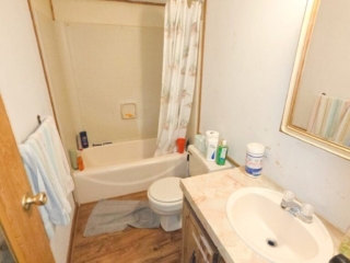A standard bathroom with a toilet, sink, bathtub, and shower curtain.